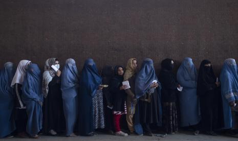 Wanita berbaris untuk menerima uang tunai di titik distribusi uang yang diselenggarakan oleh Program Pangan Dunia, di Kabul, Afghanistan, Sabtu, 20 November 2021. Terhimpit Ekonomi, Mahasiswi Afghanistan Terpaksa Putus Kuliah dan Bekerja