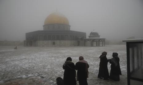 Cendekiawan Muslim Dunia Serukan Pekan Yerusalem. Wanita berdiri di dekat Masjid Kubah Batu di kompleks Masjid al-Aqsa pada pagi bersalju di Kota Tua Yerusalem, Kamis, 18 Februari 2021. 