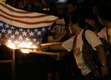 Wanita Filipina membakar bendera Amerika Serikat saat menggelar aksi demonstrasi menentang kehadiran tentara Amerika Serikat di Filipina.