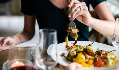 Wanita makan di restoran.