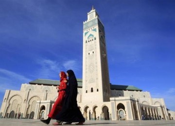 Wanita Maroko berjalan di depan Masjid Hassan II di Casablanca.