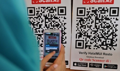 Wanita memindai QR Code menggunakan ponselnya.