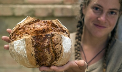 Wanita memperlihatkan roti yang baru dibuatnya.