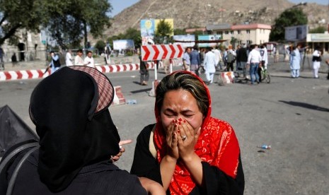 Wanita menangis di lokasi terjadinya ledakan bom bunuh diri di Kabul, Afghanistan.