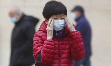 Wanita mengenaka masker di Hong Kong, Jumat (31/1). WHO sudah mendeklarasikan darurat kesehatan bagi corona yang bermula Kota Wuhan, China.