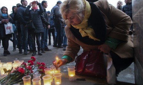 Wanita menyalakan lilin di stasiun Sennaya mengenang korban ledakan di stasiun kereta di St Petersburg, Rusia.