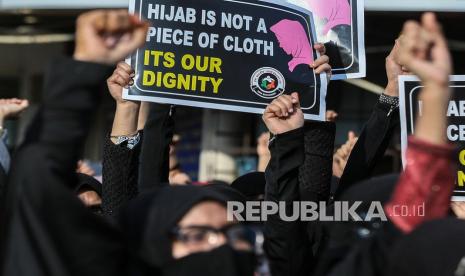 Wanita Muslim India memegang plakat dan meneriakkan slogan-slogan selama protes terhadap pembatasan jilbab di jalan Mira, di pinggiran Mumbai, India, 11 Februari 2022. Enam siswa di Government Women First Grade College di distrik Udupi, Karnataka, telah dilarang menghadiri kelas karena mengenakan jilbab dan siswa Hindu mulai mengenakan selendang safron sebagai tanda protes. Mendagri India Mengaku Lebih Suka Siswa Pakai Seragam Ketimbang Jilbab