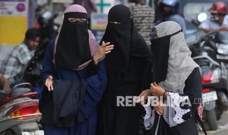  Wanita Muslim mengenakan Niqab (cadar yang menutupi wajah kecuali area mata) berjalan di jalan di Bangalore, India, 16 Februari 2022. Pengadilan Tinggi Karnataka mendengar pada 16 Februari petisi yang menentang larangan jilbab di lembaga pendidikan karena perguruan tinggi pra-universitas dilarang. dibuka setelah ditutup selama seminggu, karena deretan hijab. India telah mengalami peningkatan jumlah kejahatan kebencian dan serangan terhadap Muslim, Kristen, dan Minoritas dalam beberapa bulan terakhir. Kontroversi Jilbab, Muslim India Khawatir Semakin Terpinggirkan