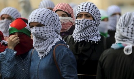 Wanita Palestina ambil posisi jelang bentrokan dengan aparat Israel di Ramallah, Sabtu (10/10). 