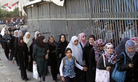 Wanita Palestina melewati sebuah pos pemeriksaan Israel di ruang terbuka sementara pria harus melalui jalan yang diberi pagar untuk menuju Masjid Al Aqsa di Yerusalem, Jumat (10/8).   (Nasser Shiyoukhi/AP)