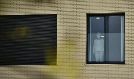 Wanita tampak dari jendela di Panti Jompo San Martin, di Spanyol utara, Kamis (19/3). Di sana sejumlah lansia dipastikan terinfeksi corona.(AP Photo/Alvaro Barrientos)