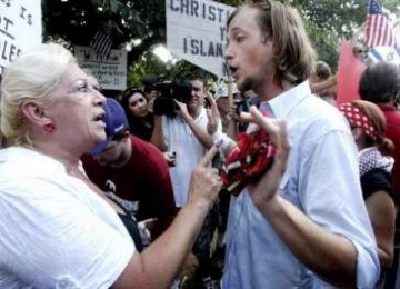 Wanita, salah satu penentang masjid (kiri) dan pendukung (kana) berdebat keras selama demonstrasi di pusat kota Rutherford County.