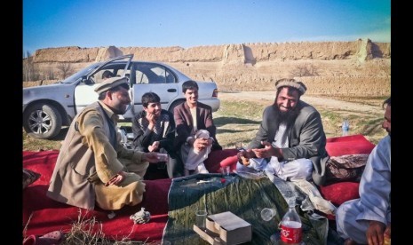 Warga Afghan piknik di kota kuno, Balkh, menggelar karpet merah dengan menu lemak domba, roti tanpa ragi, gula dengan teh dan Coca-Cola