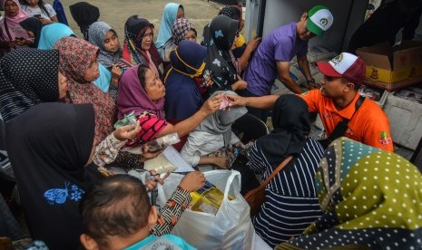 Warga antre membeli sembako pada operasi pasar murah rakyat.