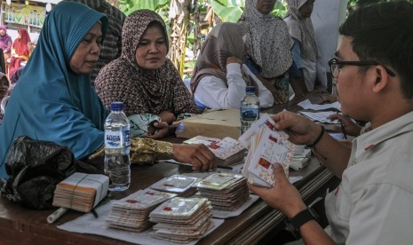 Warga antre membuat kartu bantuan pangan non tunai (BPNT) di Kantor Desa Jatimulya, Lebak, Banten, Senin (24/6). Pemerintah fokus meningkatkan daya beli kelompok masyarakat terdampak dan menjaga kelangsungan usaha, termasuk mengurangi kemungkinan pemutusan hubungan kerja (PHK) di tengah penyebaran wabah corona di Indonesia.