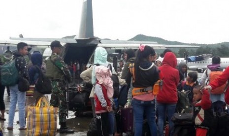 Warga antre menaiki pesawat milik TNI di Bandara Wamena, Jayawijaya, Papua, Sabtu (28/9/2019). 