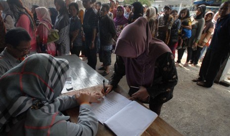 Warga antre mencairkan dana Program Simpanan Kesejahteraan Sosial (PSKS) di Kantor Pos, Tasikmalaya, Jawa Barat, Rabu (26/11). 