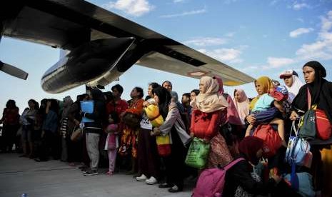 Warga antre untuk dievakuasi menggunakan pesawat Hercules di Bandara Mutiara Sis Al Jufri Palu, Sulawesi Tengah, Minggu (30/9). 