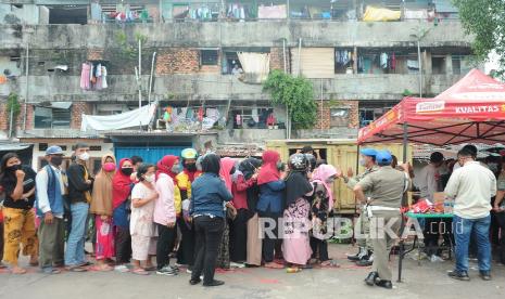 Warga antre untuk membeli minyak goreng saat operasi pasar di Kawasan Rumah Susun Palembang, Sumatera Selatan, Kamis (24/2/2022). Dinas Perdagangan Kota Palembang menggelar operasi pasar minyak goreng dengan harga Rp 13.000 per liter selama beberapa hari di sejumlah titik Kota Palembang.