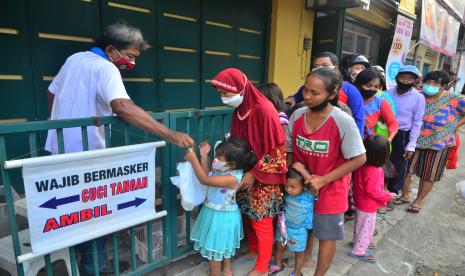 Warga antre untuk menerima paket makanan berisi nasi dan lauk pauk serta minuman di Warung Sedekah, Jalan Sunan Kudus, Kauman, Kudus, Jawa Tengah, Sabtu (16/4/2022). Warung Sedekah yang buka setiap hari saat bulan Ramadhan tersebut menyediakan ratusan paket makanan yang dibagikan secara gratis kepada warga kurang mampu untuk berbuka puasa.