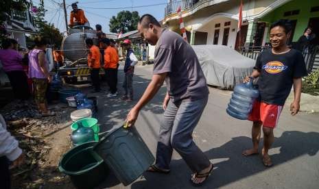 Warga antri untuk mendapatkan air bersih yang didistribusi oleh Petugas Badan Penanggulangan Bencana Daerah (BPBD) di Rancamaya, Bogor Selatan, Jawa Barat, Sabtu (18/8). 