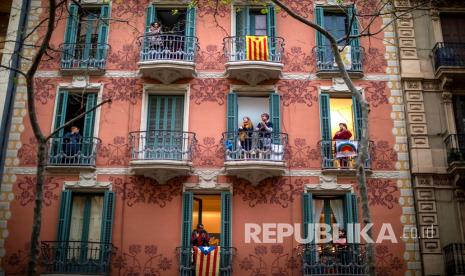 Warga apartemen bertepuk tangan dari balkon untuk mendukung staf medis yang bekerja pada wabah virus COVID-19 di Barcelona, Spanyol, Ahad (29/3).  