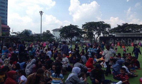 Warga asyik menyantap makan siang yang dibawa dari rumah di kawasan sekitar Alun-Alun Kota Bandung, Kamis (7/7). 