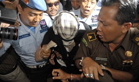  Warga Australia terpidana 20 tahun penjara dalam kasus penyelundupan mariyuana, Schapelle Leigh Corby (tengah) menutup wajahnya saat melengkapi administrasi bebas bersyarat di Kejaksaan Negeri Denpasar, Bali, Senin (10/2).   (Antara/Nyoman Budhiana)