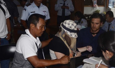  Warga Australia terpidana 20 tahun penjara dalam kasus penyelundupan mariyuana, Schapelle Leigh Corby (tengah) menutup wajahnya saat melengkapi administrasi bebas bersyarat di Kejaksaan Negeri Denpasar, Bali, Senin (10/2).   (Antara/Nyoman Budhiana)