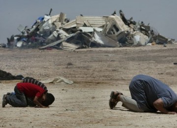 Warga Badui di Al Arakib, Israel, melakukan shalat di dekat puing rumah mereka yang dihancurkan Israel