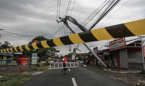 Warga berada di dekat tiang listrik yang roboh di Banguntapan, Bantul, DI Yogyakarta, Rabu (2/2/2022). Hujan deras disertai angin kencang di Kabupaten Sleman dan Bantul menyebabkan sejumlah rumah rusak serta pohon tumbang, tidak ada korban dalam kejadian tersebut