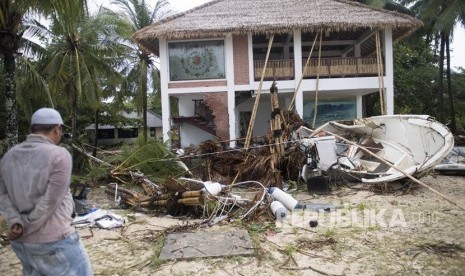 Warga berada di depan bangunan yang terdampak bencana Tsunami di Pantai Tanjung Lesung, Banten, Jawa Barat, Ahad (23/12/2018).