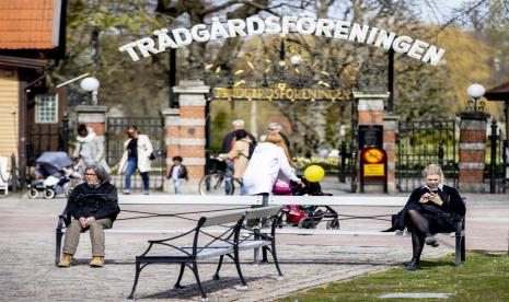 Warga berada di depan pintu masuk taman kota Tradgardsforeningen di Gothenburg, Swedia. Swedia terapkan penjarakan sosial yang diikuti kepatuhan warganya demi perangi corona. Ilustrasi. 