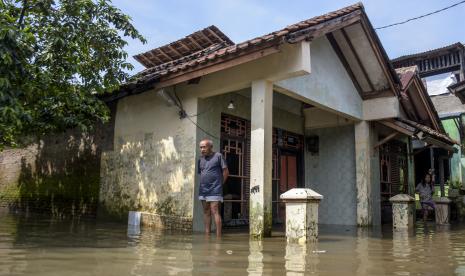 Warga berada di halaman rumahnya yang terendam banjir di Kampung Bojongasih, Kecamatan Dayeuhkolot, Kabupaten Bandung.