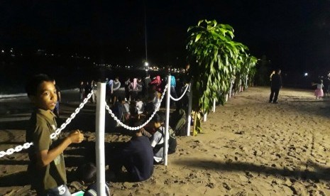 Warga berada di Pantai Senggigi, Lombok Barat, NTB, merayakan malam pergantian tahun, Ahad (31/12).