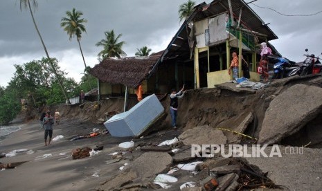 Warga berada di rumahnya yang nyaris roboh akibat abrasi, di Pantai Ulakan, Padangpariaman, Sumatera Barat, Kamis (30/11). 