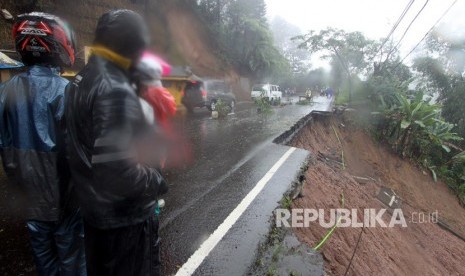 Warga berada di sekitar tempat terjadinya longsor di jalur utama Puncak Bogor, Jawa Barat, Senin (5/2). 