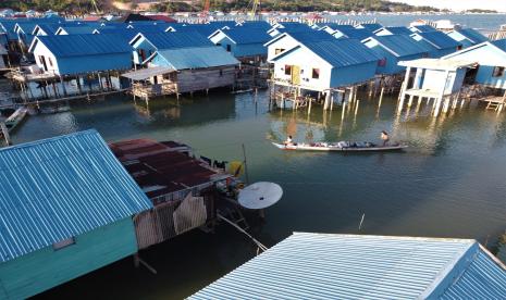 Warga berada diatas perahu melintasi rumah bantuan dari pemerintah di Desa Leppe, Kecamatan Soropia, Konawe, Sulawesi Tenggara, Selasa (1/6/2021). Sebanyak 65 unit rumah dibangun oleh Kementerian Desa, Pembangunan Daerah Tertinggal Dan Transmigrasi bagi masyarakat pesisir laut namun sebagian belum dihuni sebab sebagian warga protes karena peruntukannya oleh pemerintah desa setempat diduga tidak tepat sasaran.