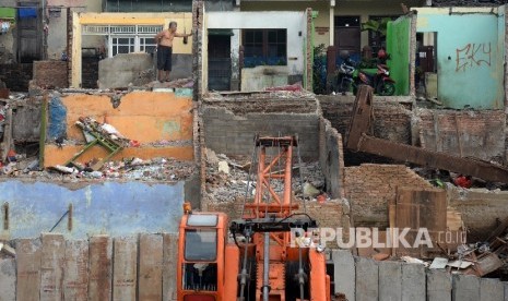 Warga berada dirumah yang sudah dibongkar di Bukit Duri, Jakarta Selatan, Rabu (14/9).