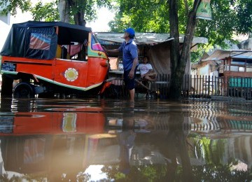 Warga berakifitas saat banjir yang melanda kawasan Petogogan, Jakarta Selatan, Minggu (12/2). (Republika/Prayogi)