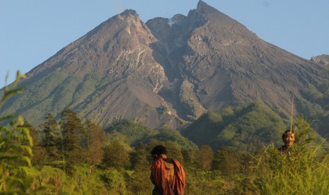 Warga beraktivitas dengan berlatar belakang Gunung Merapi.