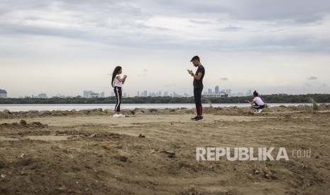 Warga beraktifitas di area pembangunan jalur Jalan Sehat dan Sepeda Santai (Jalasena) di kawasan Pantai Kita dan Pantai Maju, Jakarta, Minggu (23/12/2018).