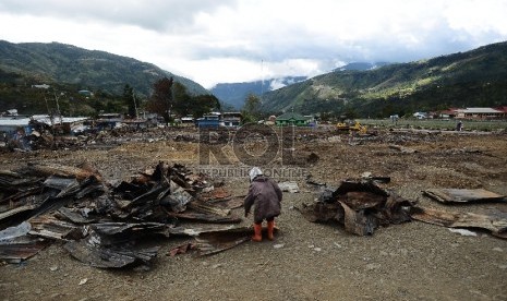   Warga beraktifitas di lokasi terbakarnya kios dan Mushollla di Tolikara, Papua, Kamis (23/7). 