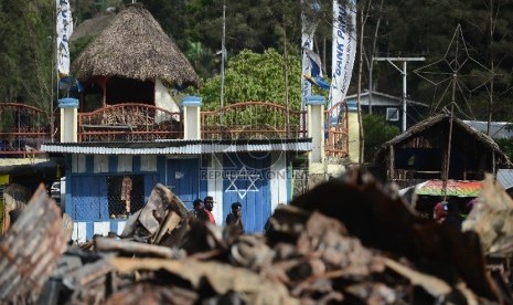 Warga beraktifitas di lokasi terbakarnya kios dan Mushollla di Tolikara, Papua, Kamis (23/7). 