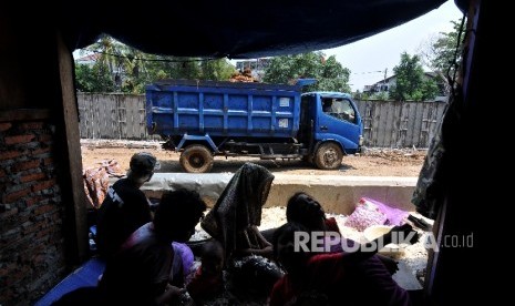 Warga beraktifitas di samping proyek pembangunan tanggul Sungai Ciliwung di Bukit Duri, Tebet, Jakarta Selatan, Jumat (22/9).