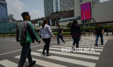 Warga beraktivitas di kawasan Bundaran Hotel Indonesia, Jakarta, Senin (16/3). Suasana di kawasan tersebut terpantau lengang berdasarkan imbauan Presiden Republik Indonesia Joko Widodo untuk mengurangi aktifitas diluar ruangan serta melakukan pekerjaan dirumah guna mencegah penyebaran virus Covid-19.(Republika/Thoudy Badai)