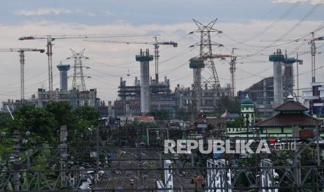 Warga beraktivitas di antara rel kereta berlatar belakang pembangunan Jakarta International Stadium di Jakarta Utara, Ahad (1/11). Otoritas Jasa Keuangan (OJK) memperpanjang durasi program restrukturisasi kredit perbankan.