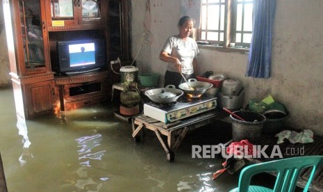 Warga beraktivitas di dalam rumahnya yang terendam banjir di Babelan, Kabupaten Bekasi, Jawa Barat, Selasa (6/2).