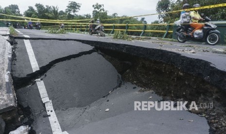 Warga beraktivitas di dekat jembatan yang ambles di Imogiri, Bantul, DI Yogyakarta, Kamis (30/11). 