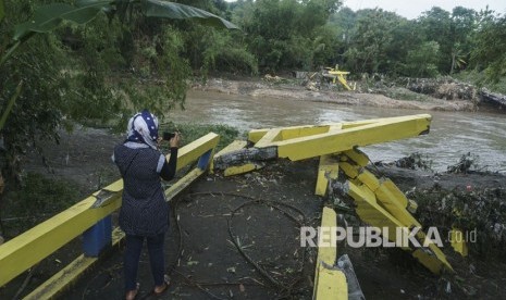 Warga beraktivitas di dekat jembatan yang rusak di Imogiri, Bantul, DI Yogyakarta, Kamis (30/11).